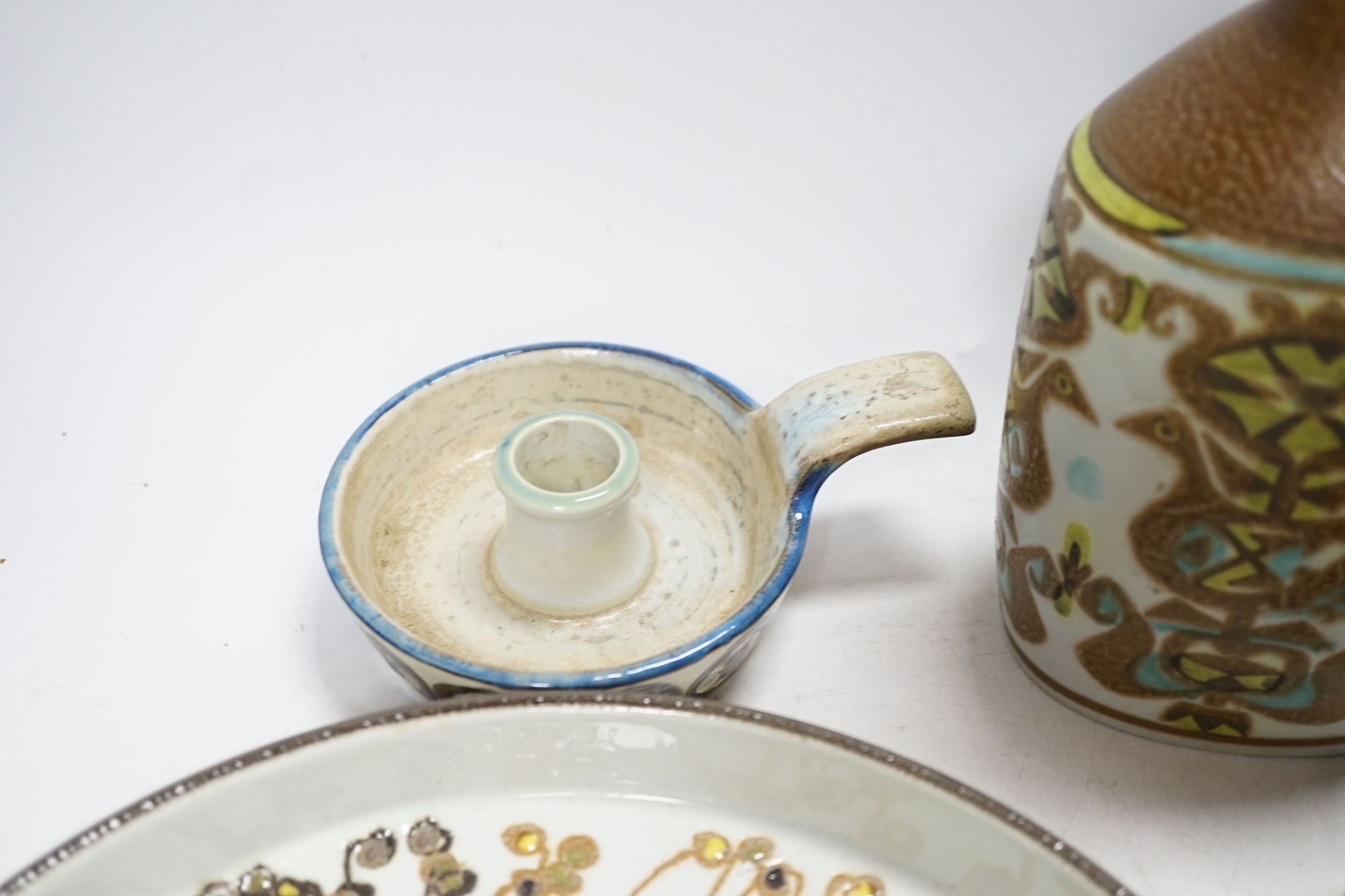 Seven Royal Copenhagen fajance items; a vase decorated with birds, a vase, decorated with fish, a small pot, a holder, two circular dishes and a teapot stand, largest dish 26cm diameter